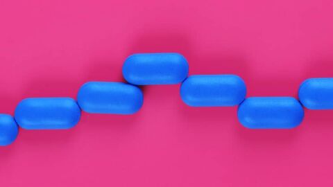Blue pills on a pink background