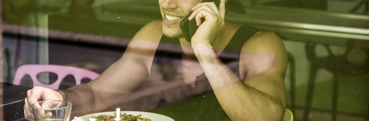 Man having breakfast talking on his mobile phone