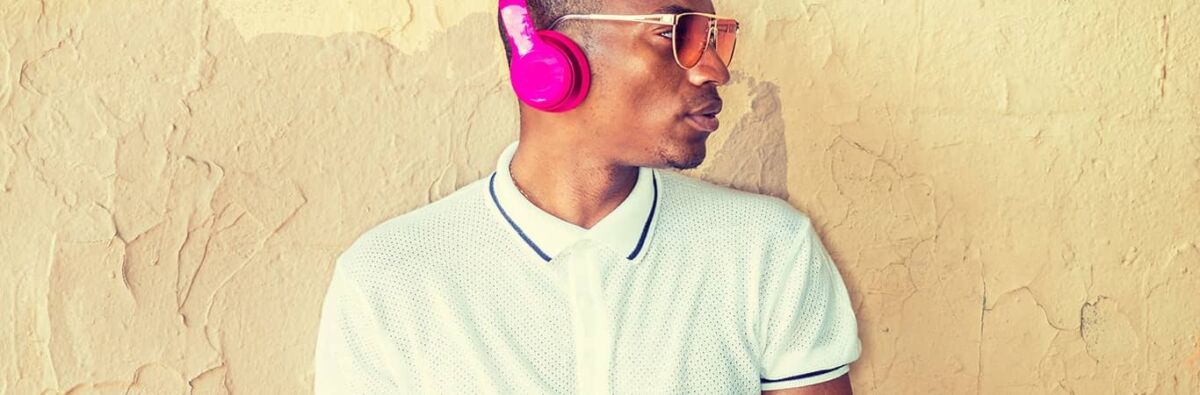 Man with sunglasses with pink headphones and white polo shirt