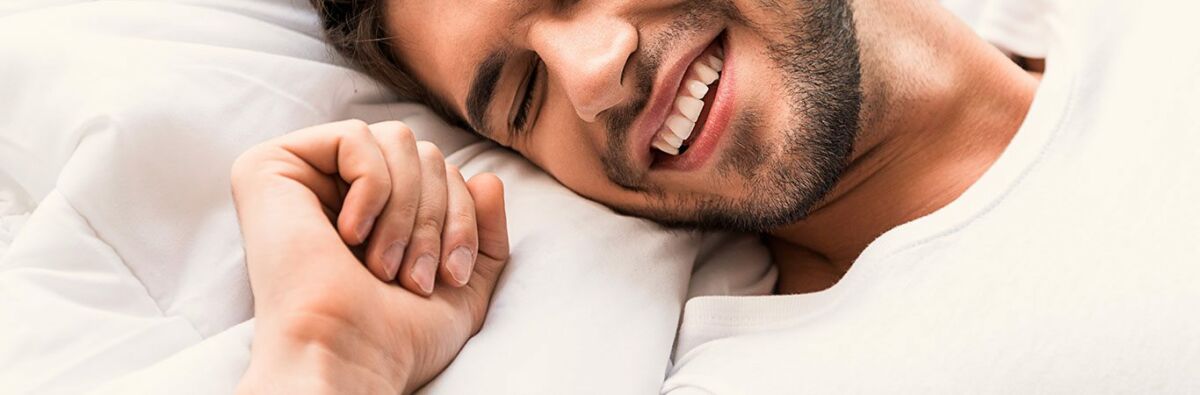 happy gay man with head on pillow
