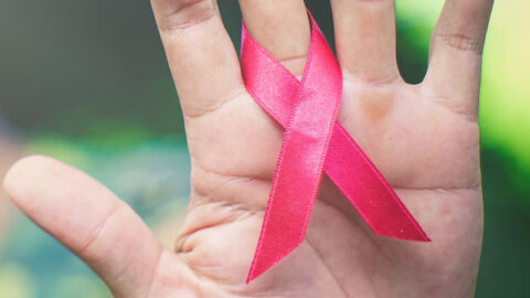 Red HIV AIDS ribbon around finger
