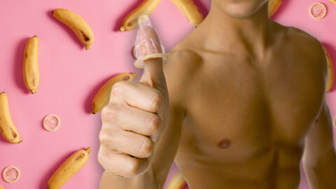 Shirtless man with condom on thumb, on pink background with bananas and condoms