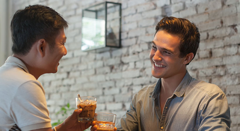 Two Men Cheers Toast Drink Ice Coffee, Asian Mix Race Friends Guys Happy Smile Sitting at Cafe Natural Light