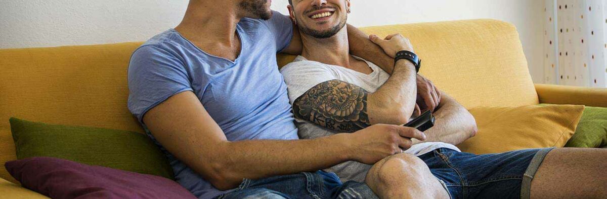two men smiling sitting on a lounge
