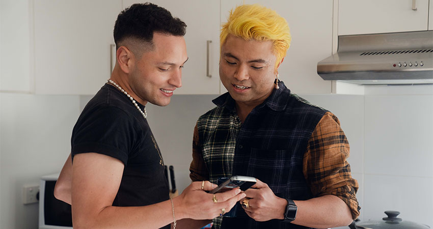 couple-look-happily-at-phone-in-kitchen