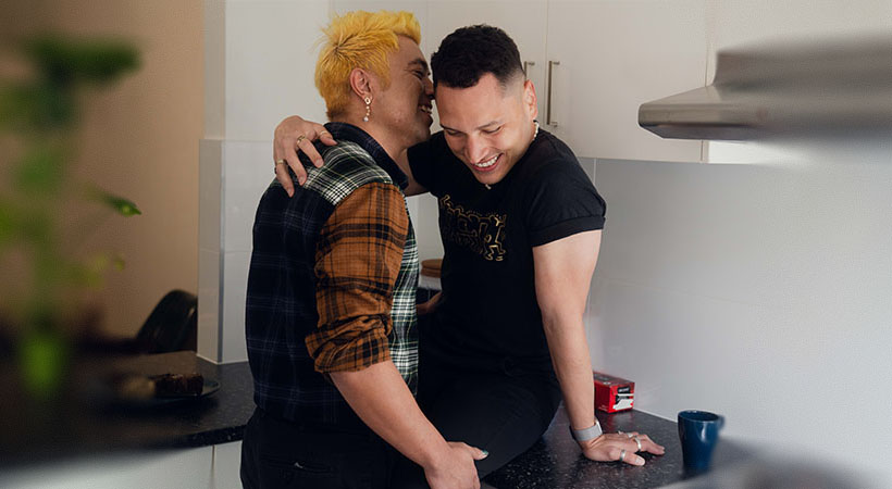 happy-couple-cuddle-on-kitchen-bench