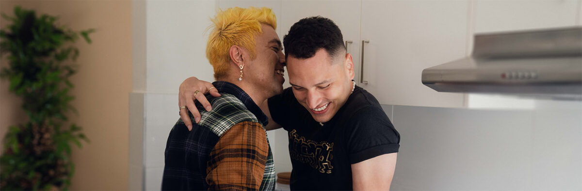 happy-couple-cuddle-on-kitchen-bench