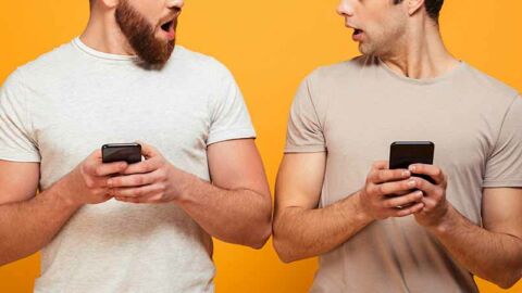 two guys on mobile phones looking shocked at each other