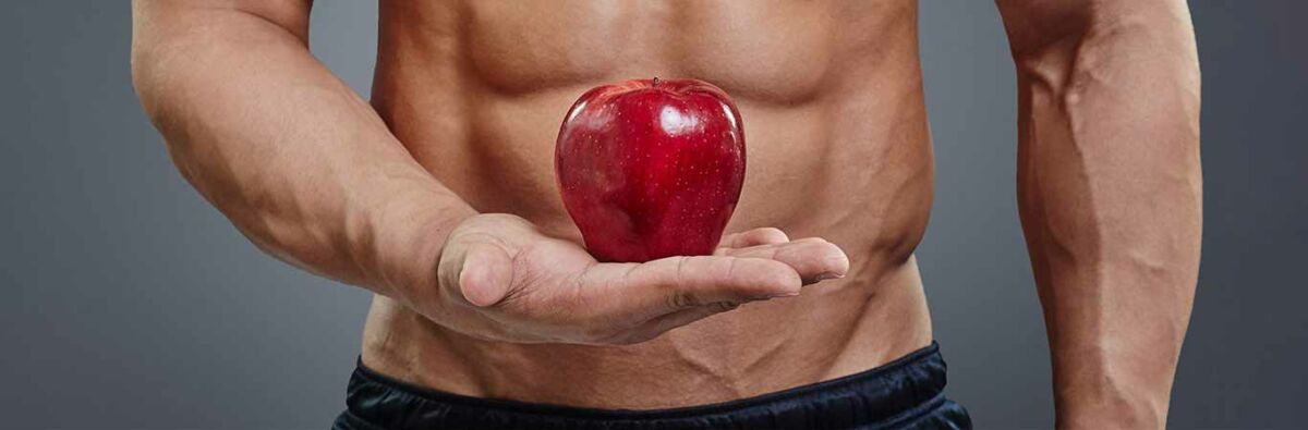 muscled man holding red apple