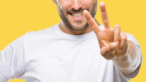 smiling man holding up two fingers