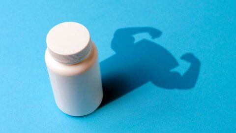 white PrEP pill bottle on blue background with strong arms in shadow
