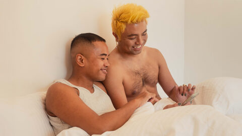 happy-asian-couple-on-phone-in-bed