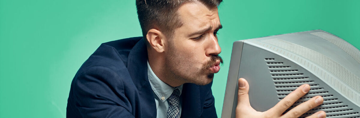 suited man kissing old computer monitor