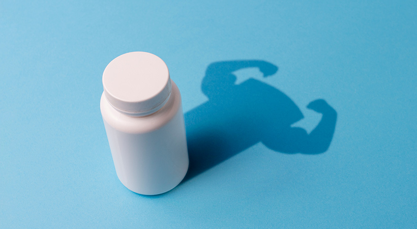 PrEP pill bottle on blue background with strong arms in shadow