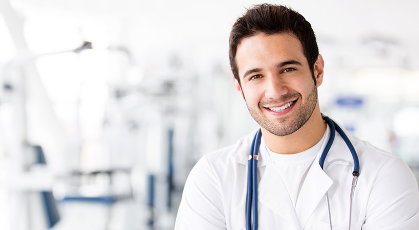 male doctor smiles with stethoscope round his neck