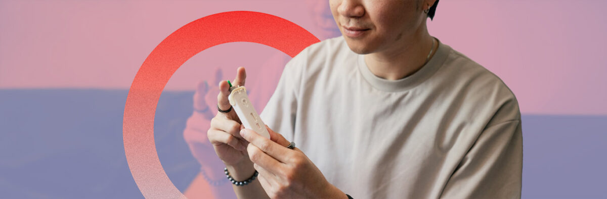 Chinese man holding a HIV self-test kit on pale red background