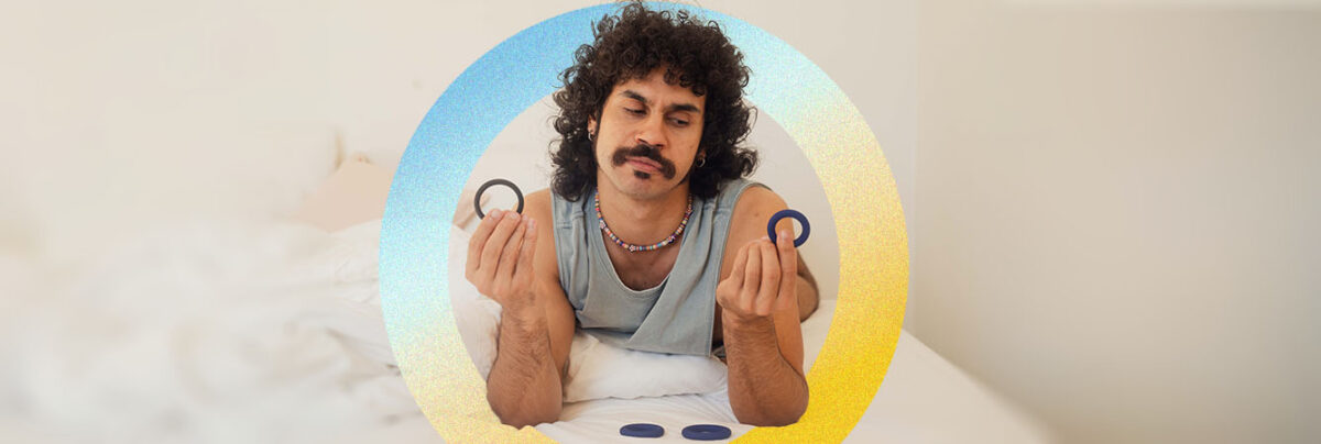 Young First Nations guy holding cock rings in bed, with blue yellow circle icon