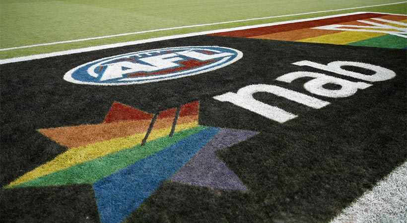 Australian afl football field with afl and sponsor logos in rainbow designs on the ground for pride game