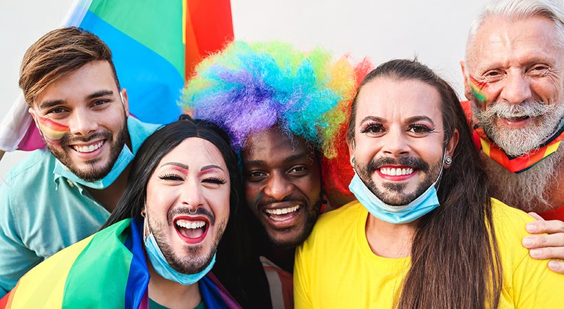 group of five happy and diverse queer people dressed for a pride party