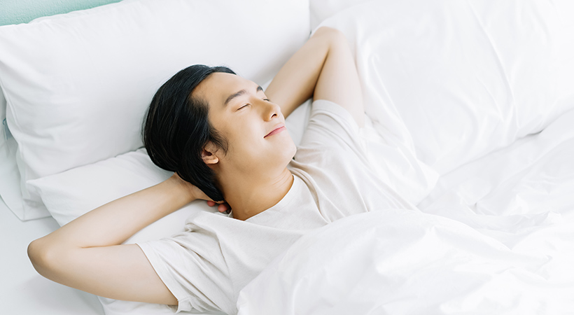 young man comfortable in bed with clean linen