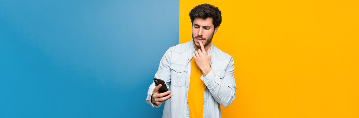 man looks at mobile phone quizzically