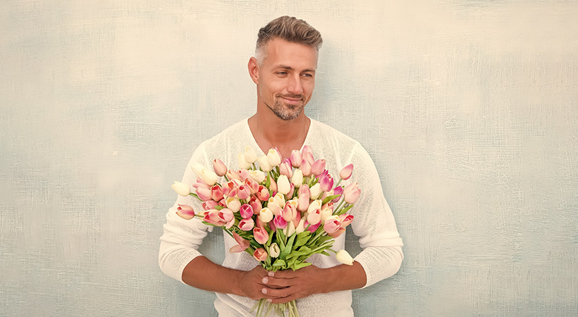 handsome man holds large bunch of tulip flowers