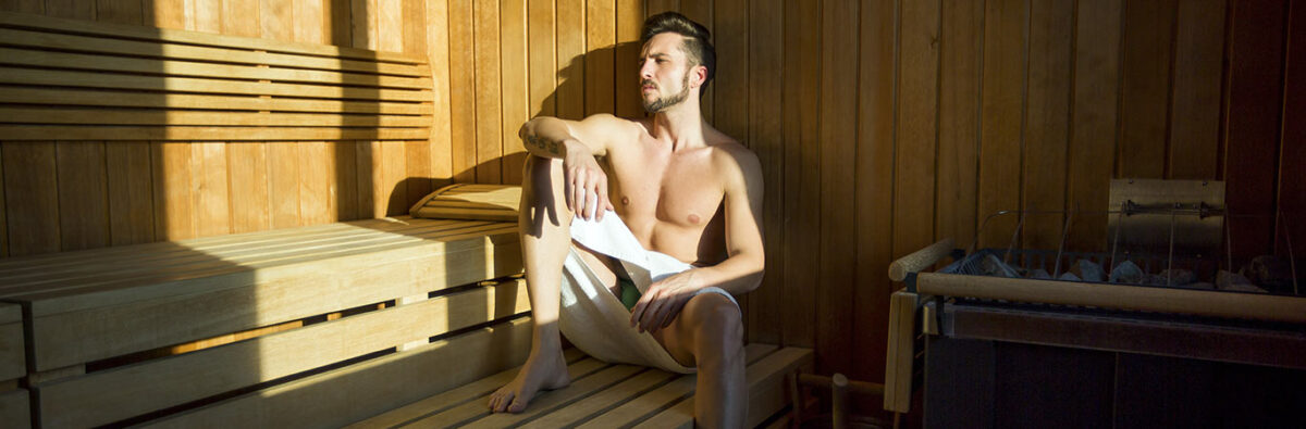 handsome man in towel relaxes at gay sauna