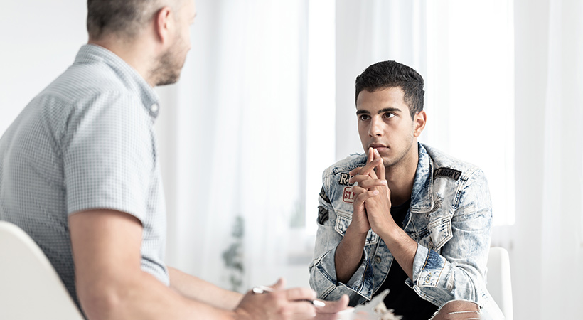 young spanish man talks to therapist