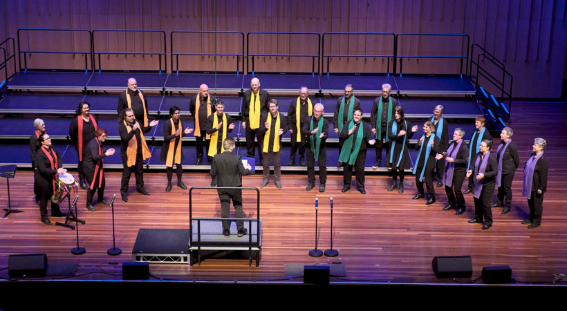 members of canberra qwire choir sing on stage