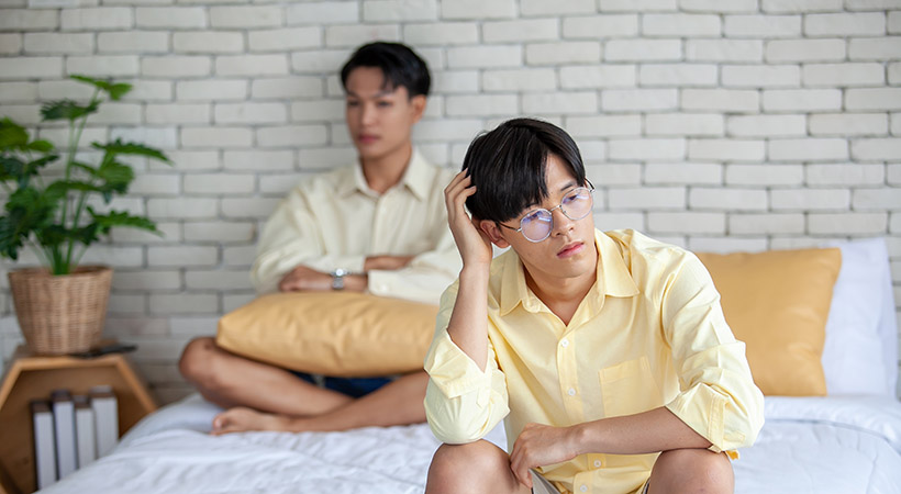 Asian gay couple are quarreling, angry or sad on bed in home