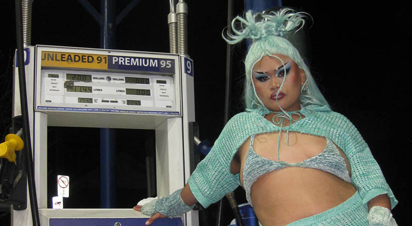 drag performer BluberryBakla posing at petrol station in blue outfit