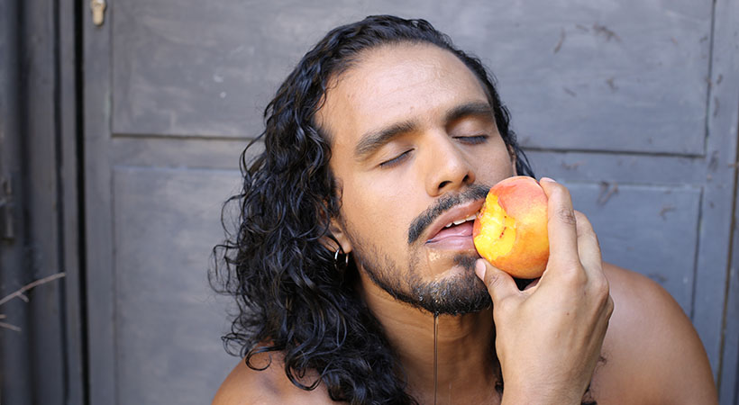 man-seductively-eats-peach