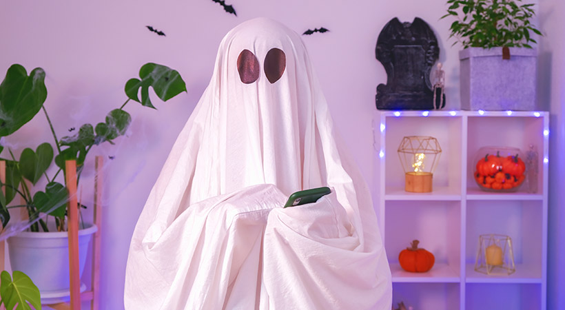 The Halloween Ghost uses a mobile phone to surf the Internet, 