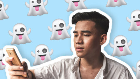 young-asian-man-looks-distressed-at-phone-with-ghosts-emoji-on-blue-background