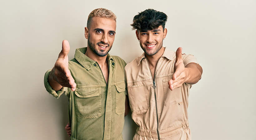 middle-eastern-couple-in-jumpsuits-with-handshake-to-camera