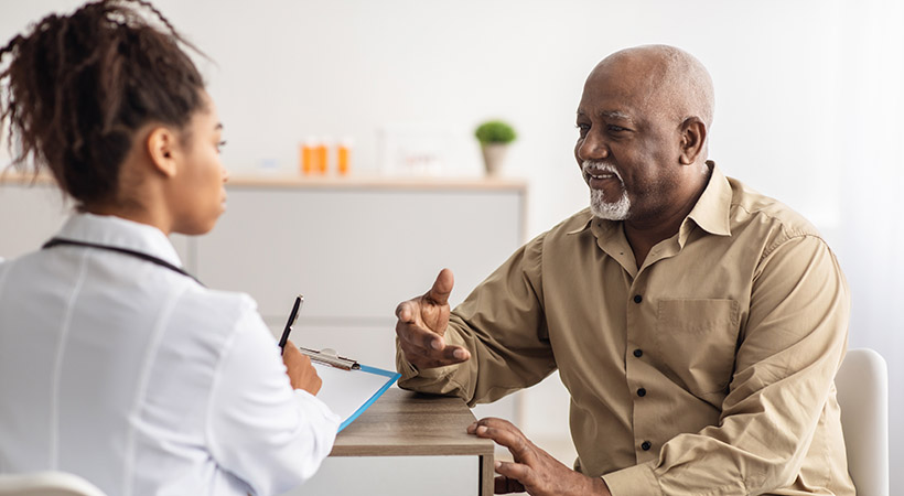 Older black man talking to female doctor