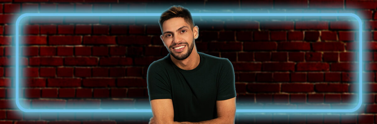 comedian-AJ-lamarque-on-red-brick-wall-with-blue-fluro-lights