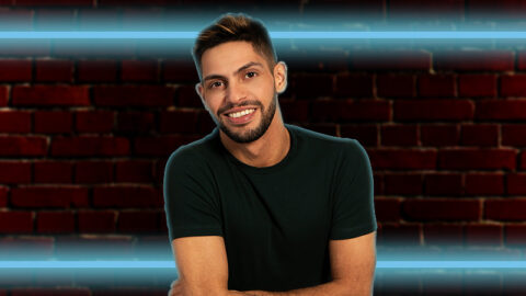 comedian-AJ-lamarque-on-red-brick-wall-with-blue-fluro-lights