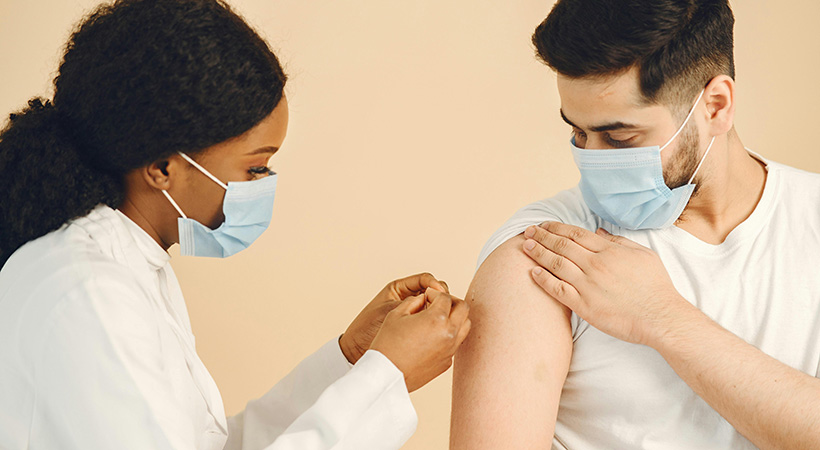 doctor-giving-male-patient-a-bandaid-after-injection