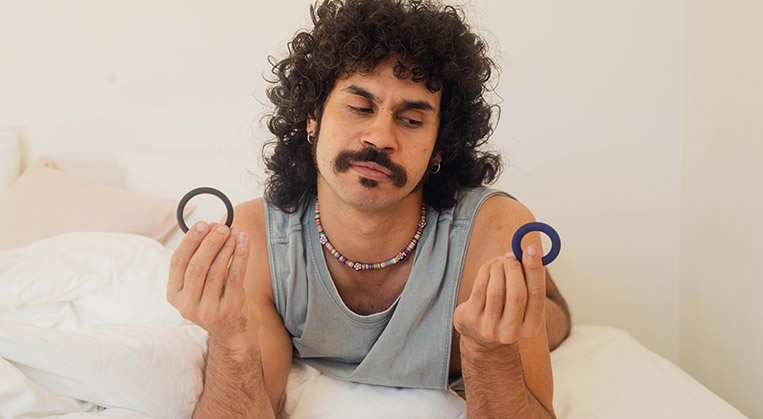 young-first-nations-man-holding-cock-rings-in-bed