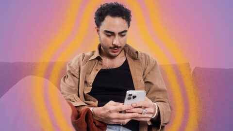 Arabic person looks surprised at phone on blue purple background