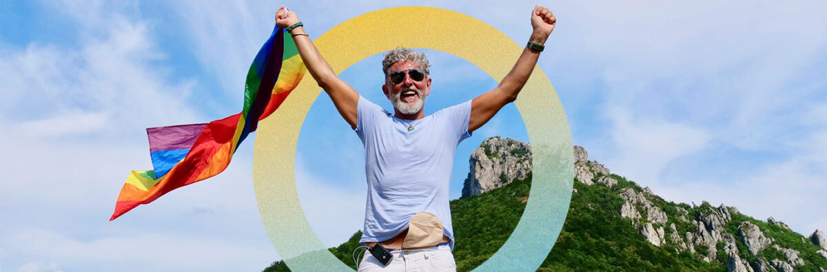 Gray-haired senior elderly man diabetic bisexuality with a beard and sunglasses holding a rainbow LGBTQIA flag on nature. Celebrates Pride Month, Rainbow Flag Day, gay parade