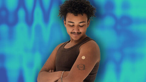 Ghanian man smiling at injection bandaid on blue background