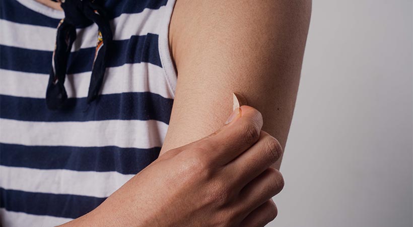 Man taking off bandaid from arm