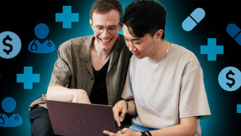 Happy Chinese and French couple looking at a computer together, on black background with blue health icons around