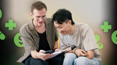 Happy couple look at phone together, green health icons in background