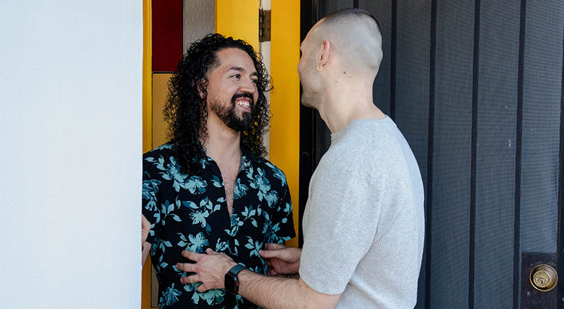 Colombian couple entering house with yellow door