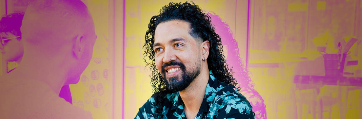 Colombian man smiling at figure, busy cafe background in pink and yellow duotone